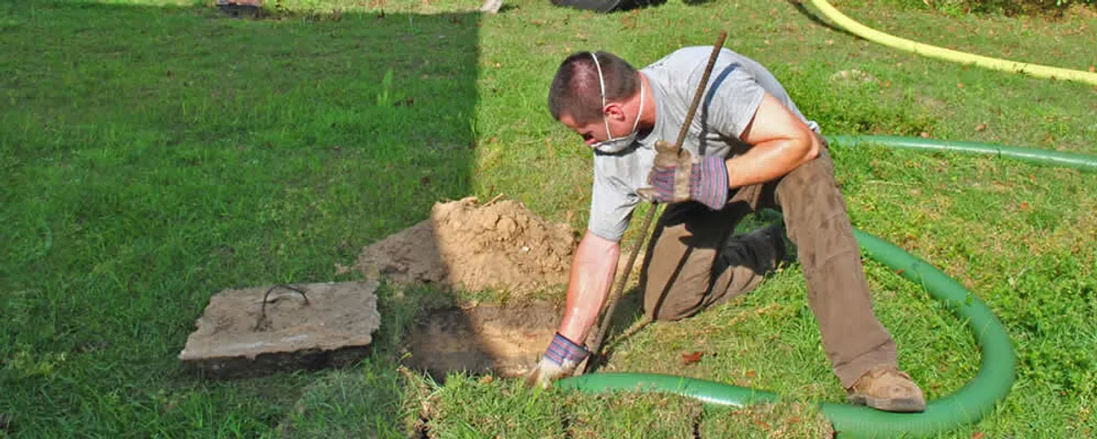 Septic pumping technician servicing a residential septic tank in Albany, NY