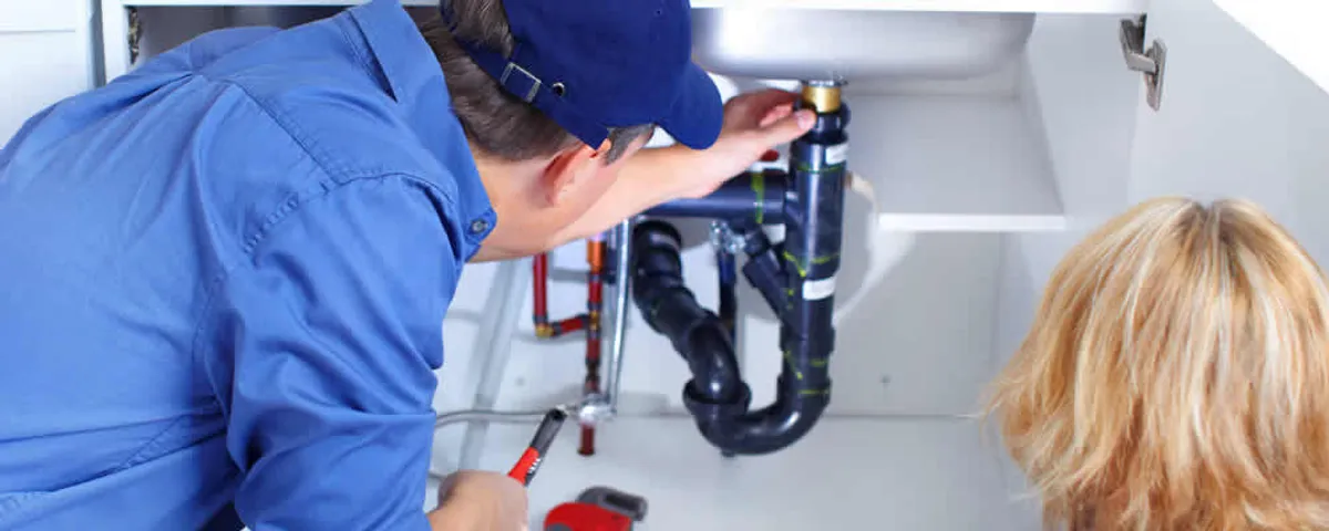 Plumber repairing under-sink drain pipes and fittings in Albany, NY